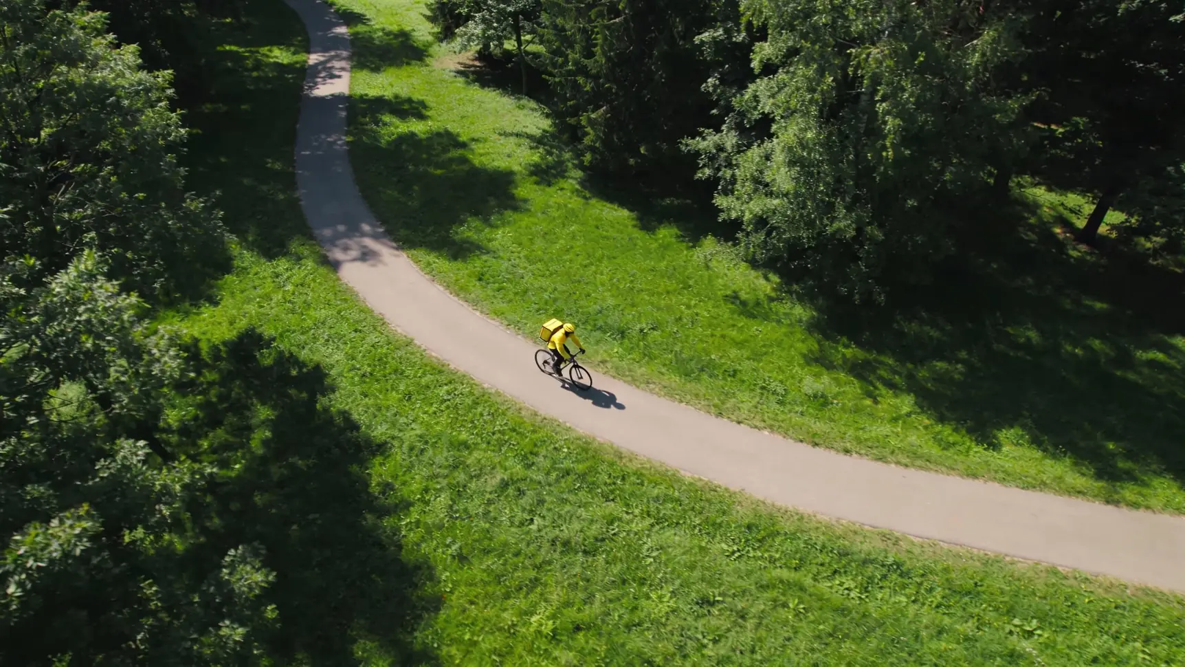 Велокурьер на современном велосипеде быстро едет по городской улице. Велокурьер на современном велосипеде быстро едет по городской улице.